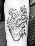 Herz-Tattoo, fineline blackwork Tätowierung mit Blumen.